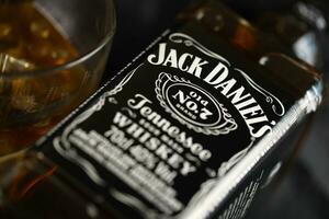 KYIV, UKRAINE - MAY 4, 2022 Jack Daniels original alcohol bottle on wooden table with black fabric photo