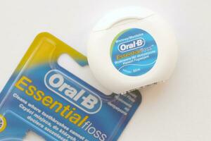 KYIV, UKRAINE - JULY 7, 2023 Oral-B Essentail Floss. Waxed dental floss in round case photo