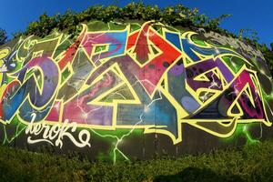 Colorful background of graffiti painting artwork with bright aerosol strips on metal wall photo