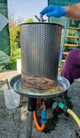 The process of making homemade grape wine. The operation of a hydraulic press to obtain grape juice for fermentation. photo