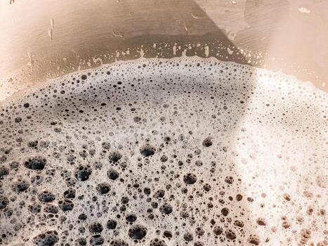 The process of making homemade grape wine. The operation of a hydraulic press to obtain grape juice for fermentation. Close-up of freshly squeezed grape juice photo