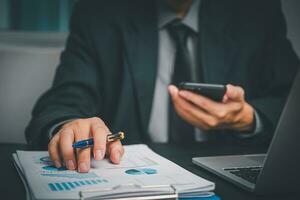 Businessman Growth through Strategic Data Analysis Digital Connection and Planning Graphs and Charts on Laptop, Using Phone for Communication Modern Office Technology. photo