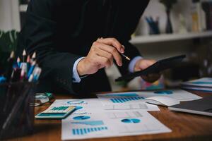 businessman working accountant document graph and chart on desk using calculator for calculate finance report in office. photo