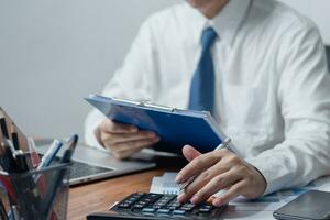 man pressing a calculator accounting and finance banking. Business marketing, money management, Tax and Investment Concept. photo