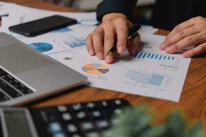 businessman working accountant document graph and chart on desk using calculator for calculate finance report in office. photo