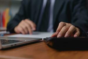 Man using calculator working with data analysis and financial planning accounting and bookkeeping tasks. Business marketing investment analysis economy Information growth concept. photo