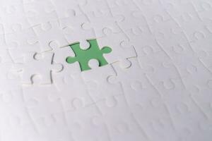 Puzzle pieces on green background.white jigsaw puzzle pieces copy space for text, top view. photo