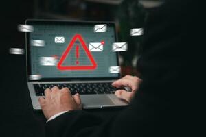 Man using laptop computer with hacker alarm protecting data from cybercrime in the digital age. Internet security and privacy defending against data theft and email breach. photo