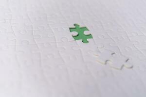 Puzzle pieces on green background.white jigsaw puzzle pieces copy space for text, top view. photo