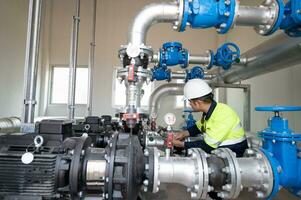 mantenimiento ingenieros inspeccionar el sistema de bombeo estaciones y tubería entregando limpiar agua y agua almacenamiento tanques para el comunidad. foto