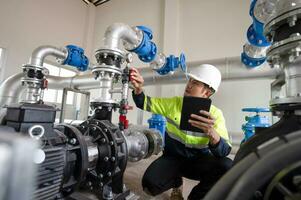 mantenimiento ingenieros inspeccionar el sistema de bombeo estaciones y tubería entregando limpiar agua y agua almacenamiento tanques para el comunidad. foto