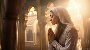 young muslim woman praying ,Young muslim woman praying in mosque photo