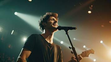 Handsome young male singer holds a microphone stand and performs on a concert stage. photo