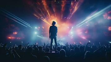 hermoso joven masculino cantante sostiene un micrófono estar y realiza en un concierto escenario. foto