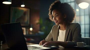 sonriente africano americano mujer de negocios sentado a mesa en su hogar oficina, leyendo documentos y trabajando utilizando ordenador portátil foto