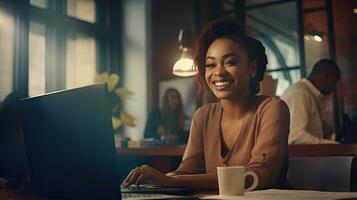 Smiling African American businesswoman sitting at table in her home office, reading documents and working using laptop photo