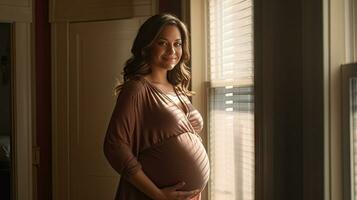 A pregnant woman stood smiling in the corner of the window with light streaming through the window. photo