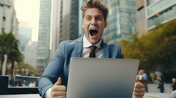 Young businessman in a successful suit shouts with joy Receive notifications from your laptop photo