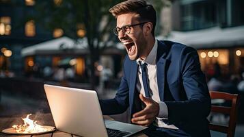 Young businessman in a successful suit shouts with joy Receive notifications from your laptop photo