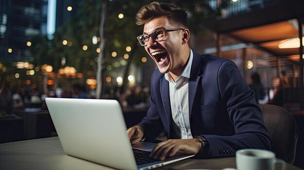 Young businessman in a successful suit shouts with joy Receive notifications from your laptop photo