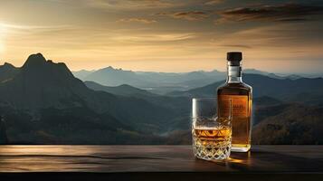 A whiskey glass and a bottle on a bar table In the background are mountains and a sea of mist at sunset. photo