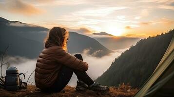 girl hiker in a tent and holding a cup mountains in the background photo