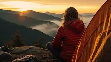 girl hiker in a tent and holding a cup mountains in the background photo