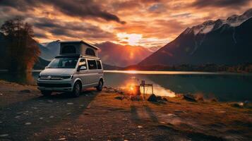 familia cámping coche Vamos en fiesta en un autocaravana, estacionado siguiente a el río, con el montañas detrás el puesta de sol. foto