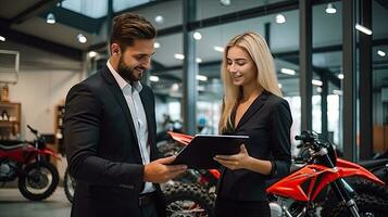 A saleswoman holds a Smiling Gym file. Behind it is a new big bike in the showroom. photo