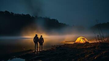 Night camping on the banks of male and female hikers There is thick fog along the river. photo