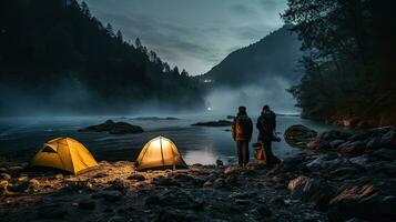 Night camping on the banks of male and female hikers There is thick fog along the river. photo