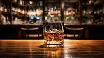 A glass of whiskey on the bar table behind the bar photo