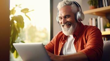 Senior man wearing headphones making a video call on a tablet photo