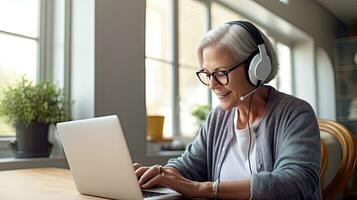 Senior woman wearing headphones making a video call on a tablet photo