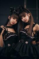 two asian women dressed in gothic outfits posing for the camera generative ai photo