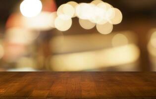 Mock up for space. Empty dark wooden table in front of abstract blurred bokeh background of restaurant . can be used for display or montage your product photo