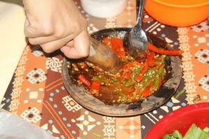 hands are grinding chilies, kneading chilies complete with chilies photo