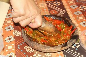 hands are grinding chilies, kneading chilies complete with chilies photo