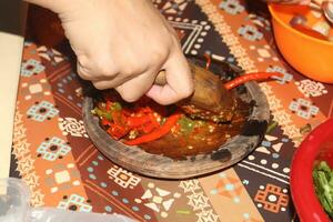 hands are grinding chilies, kneading chilies complete with chilies photo