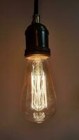 Vintage incandescent lamp. Old incandescent light bulb on a dark background. Vintage item photo