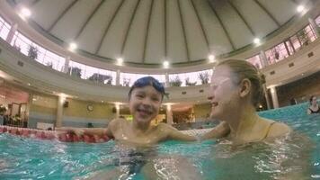 Joyful Kid with mom bathing in the pool video