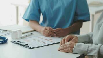 Female doctor in white coat holding hand of senior patient, giving help, comfort, psychological support, empathy at appointment. Elderly medic care, geriatric healthcare concept. Close up video