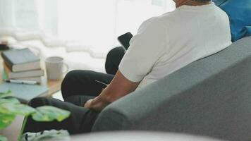 Happy senior couple using remote control to change channel. Seniors watch TV for entertainment while man using remote control. Wife and old man sitting on couch in living room with television show. video