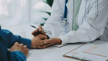 Doctor and patient sitting and talking at medical examination at hospital office, close-up. Therapist filling up medication history records. Medicine and healthcare concept. video