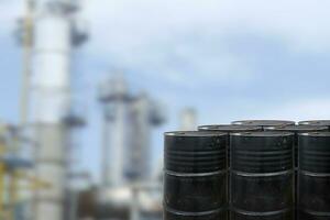 Black oil barrels against with Oil refinery blurred background photo