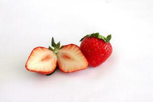 Whole and sliced piece strawberry fruit isolated on white paper background. photo