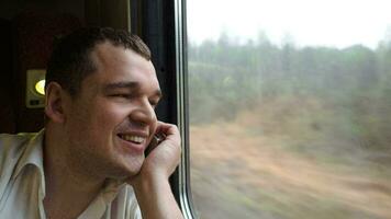 joven hombre teniendo emocionante teléfono hablar en el tren video