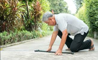 Asian senior man falling down at home in the backyard caused by myasthenia Muscle Weakness and the nurse came to help support. Concept of old elderly insurance and health care photo