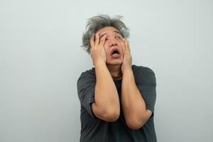 Portrait of a furious senior grey-haired man yelling and screaming and gesturing in fear with hands and face on isolated background photo