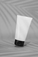 3d rendering A white tube of cosmetics green color background. The concept of natural cosmetics. Mockup. photo